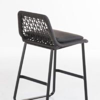 A modern bar stool featuring a woven backrest, black cushioned seat, and a sturdy metal frame, ideal for outdoor patios or indoor kitchen islands.