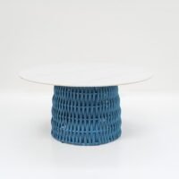 Front view of a modern round table featuring a white marble - like top and a blue woven rattan base, suitable for outdoor or indoor use.