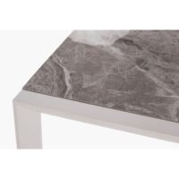 Outdoor Ethan marble dining table detail, showing marble texture and precise top-to-frame connection.
